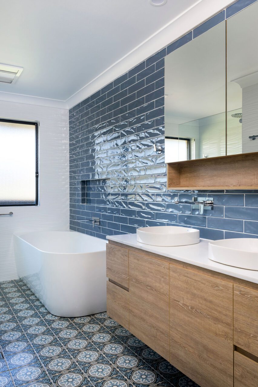 Boho bathroom with blue subway wall tiles and patterned floor tiles