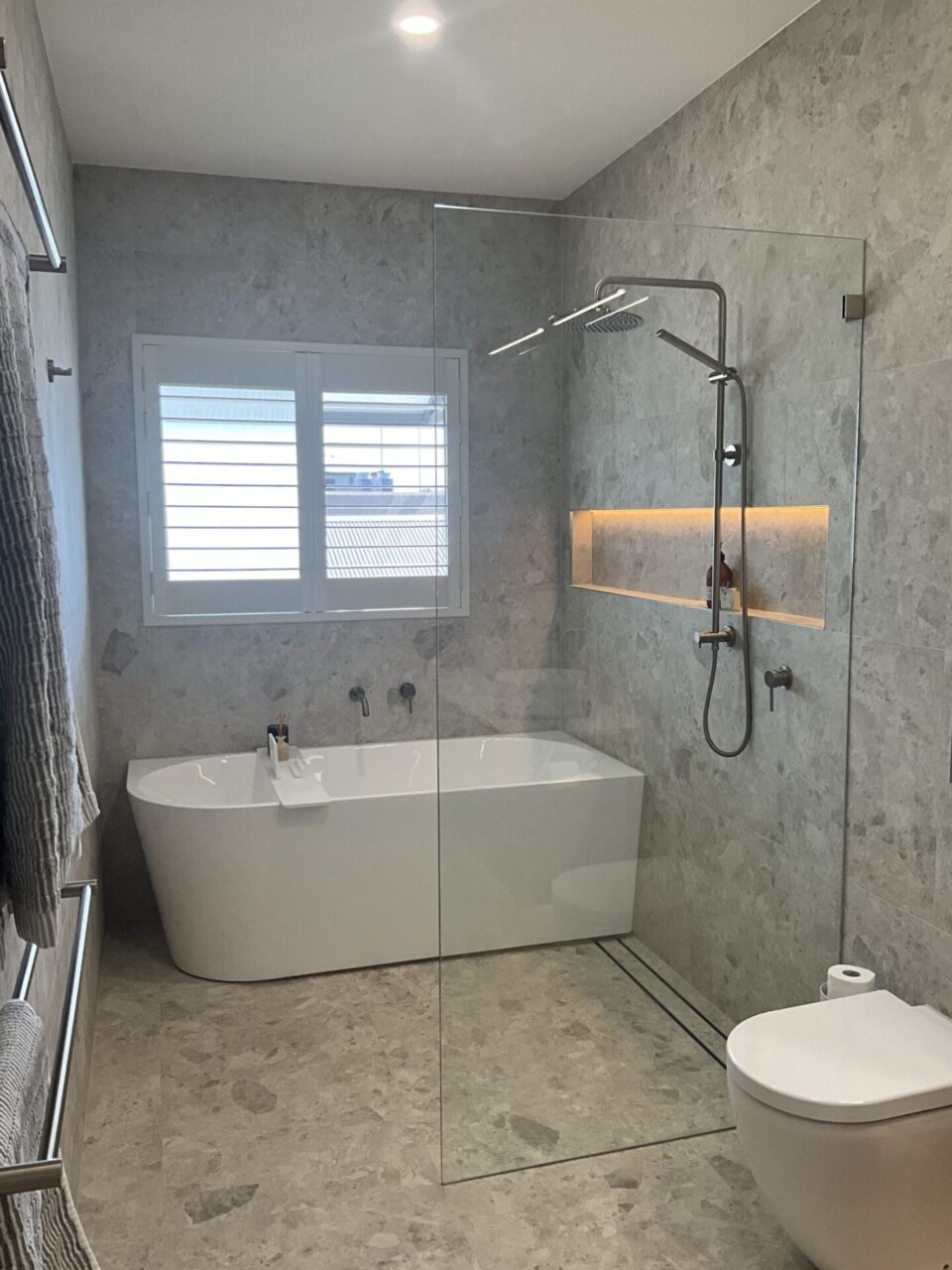 Combined shower and bath wet area with freestanding bath and frameless glass shower screen