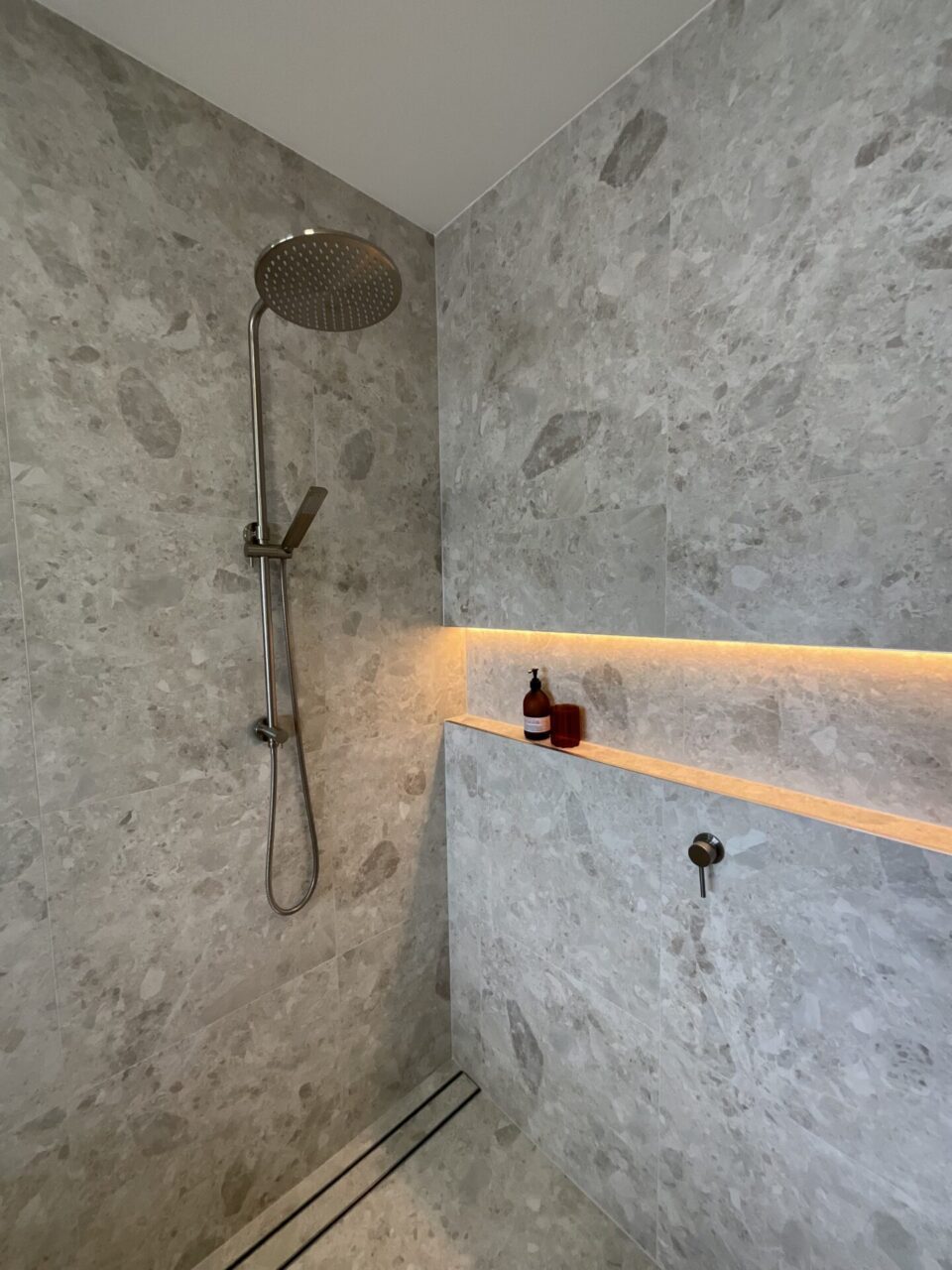Recessed shower niche with integrated LED lighting and Norrock Warm White tiles